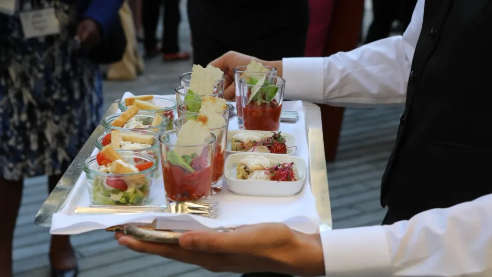 Servicekraft bringt Speisen an den Tisch